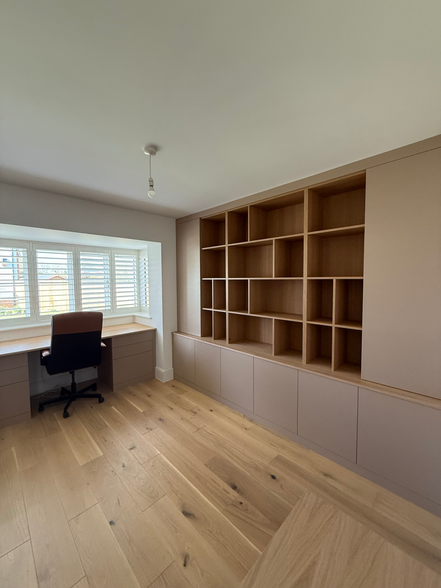 Bespoke home office with fitted window desk, oak shelving and handleless cabinetry
